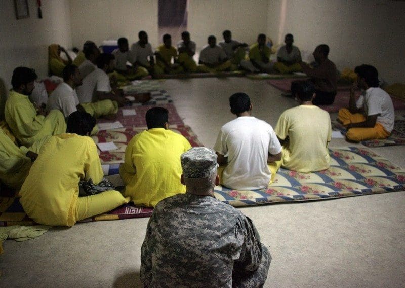 A US Army soldier listens in on an Islamic discussion course for Iraqi detainees inside the Camp Bucca detention centre located near the Kuwait-Iraq border، on May 19، 2008. There are approximately 22،000 detainees being held by US forces in two detention facilities in Iraq، up from only about 14،000 before the American troop surge this year. Camp Bucca currently holds 19،070 detainees in 33 separate compounds. The detainee population contains، juveniles، insurgents of all anti-coalition groups in Iraq، and innocent Iraqis detained during military operations. Military officials have initiated programs for the detainees in the detention facility including educational classes، Islamic discussion courses، work programs، art classes and a vigorous review board to discuss with detainees the circumstances surrounding their arrest.، Image: 25525121، License: Rights-managed، Restrictions:، Model Release: no، Credit line: Profimedia، AFP