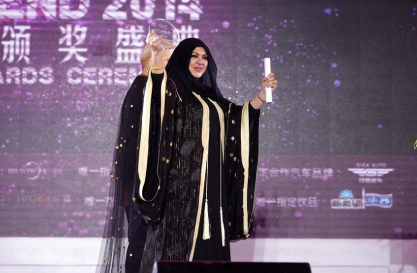 منى المنصوري وهي تحمل جائزة ملكة الموضة لآسيا عام 2014