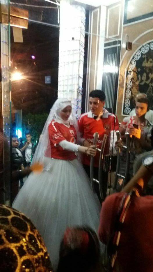 عروسة وعريس يرتدي قميص النادي الاهلي