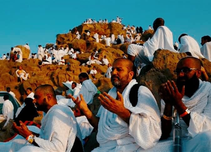 يبدو في الصورة مجموعة من الحجاج يدعون الله على جبل عرفات