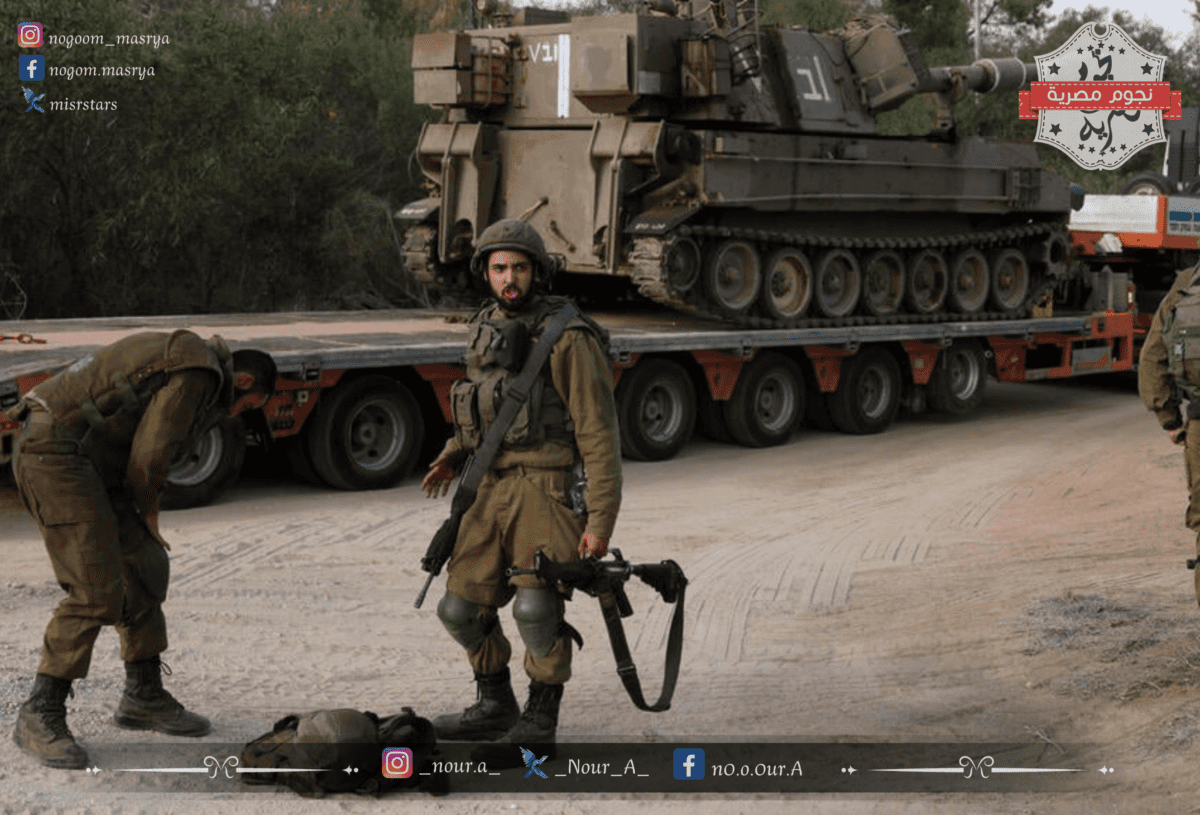 إحدى جنود الكيان الصهيوني بجوار ناقلات جنود مدرعة تابعة للجيش الإسرائيلي بالقرب من حدود غزة - مصدر الصورة: موقع ynetnews