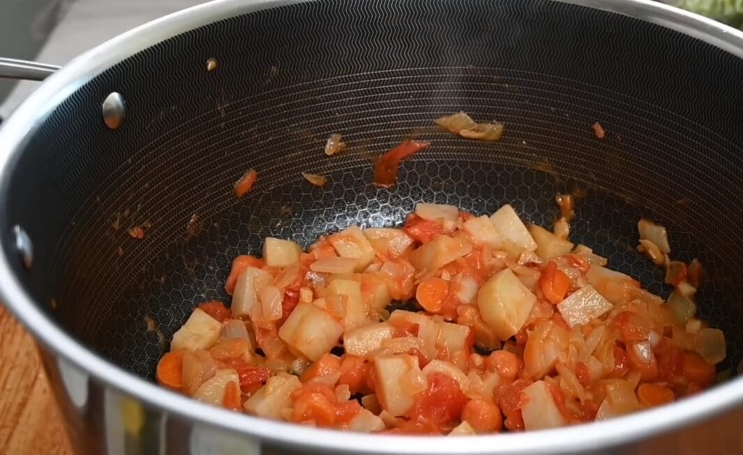 ثم نضيف البطاطس والطماطم والجزر ونقلبهم لمدة 5 دقائق حتى تذبل المكونات.