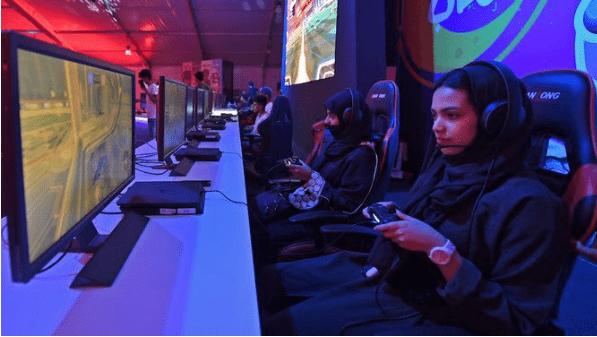 تشهد السعودية ثورة في قطاع الألعاب الإلكترونية، حيث يعد هذا السوق واحدًا من القطاعات الواعدة التي تتطلع المملكة إلى استثمارها بشكل كبير، بفضل انتشار واسع للألعاب الرقمية بين شرائح المراهقين والشبان، يشهد هذا القطاع تسارعًا هائلًا في الإيرادات. السعودية تحقق انفجارًا في صناعة الألعاب الإلكترونية تقول الإحصائيات إن أكثر من 23.5 مليون شخص في المملكة يعشقون الألعاب الإلكترونية، ممثلين نسبة تتجاوز 67% من إجمالي السكان، ويبرز عدد لاعبين محترفين يتجاوز 100 لاعب يشاركون في بطولات عالمية، حققوا إنجازات كبيرة على الساحة العالمية. تشير توقعات شركة الإتمام الاستشارية إلى أن قيمة سوق الألعاب في السعودية ستصل إلى 3.7 مليار ريال في 2023، وتستهدف زيادتها إلى 9.3 مليار ريال بحلول عام 2030، وتأتي هذه النجاحات جزءًا من دعم حكومي كبير، حيث أسهم إنشاء الاتحاد السعودي للرياضات الإلكترونية في تنظيم بطولات محلية ودعم اللاعبين المحليين، وأطلق الدوري السعودي الإلكتروني في عام 2022، وشهدت المنافسات مشاركة أبرز الفرق واللاعبين. يتوقع أن يستمر النمو الكبير في هذا القطاع، وسيسهم بشكل كبير في تعزيز الاقتصاد الرقمي في المملكة العربية السعودية. السعودية تضع استراتيجية استثمارية ضخمة في قطاع الألعاب الإلكترونية تواصل المملكة العربية السعودية خطواتها الرائدة في تعزيز دورها في قطاع الألعاب الإلكترونية، حيث أعلنت عن استثمارات ضخمة تبلغ حوالي 142 مليار ريال سعودي بهدف تحويل نفسها إلى مركز عالمي للرياضات الإلكترونية بحلول عام 2030، هذه الخطوة تعكس التزام المملكة بتعزيز الاقتصاد الرقمي ودعم قطاع الألعاب الإلكترونية الذي يشهد نموًا هائلًا. من بين الاستثمارات المخططة، تتضمن مجموعة "سافي جيمز جروب"، التابعة لصندوق الاستثمارات العامة السعودي، إنفاق حوالي 50 مليار ريال للاستحواذ وتطوير إحدى أفضل منصات الألعاب الإلكترونية، كما تشمل الاستثمارات الأخرى شراء حصص في عدة شركات ودعم شركات رائدة في صناعة الألعاب. تأتي هذه الاستثمارات في سياق التوجه العالمي نحو صناعة الألعاب الإلكترونية، حيث تشير توقعات موقع ستاتيستا إلى أن حجم سوق ألعاب الفيديو العالمي سيصل إلى 957 مليار ريال في عام 2023، ومن المتوقع أن يتجاوز 1.199 تريليون ريال في عام 2026. من اللافت للنظر أن ألعاب الهواتف الذكية ستكون الرائدة في هذه الصناعة بحصة تقدر بـ 907 مليار ريال من الإيرادات المتوقعة لعام 2026، يليها ألعاب الحواسب الشخصية، والألعاب المنزلية، والإعلانات التفاعلية داخل التطبيقات. تعتبر هذه الخطوات استراتيجية ذكية تعزز دور السعودية كقوة رائدة في عالم الألعاب الإلكترونية وتدعم رؤيتها لتحقيق التنوع الاقتصادي وجعل الابتكار والتكنولوجيا من ركائز تطويرها المستدام.